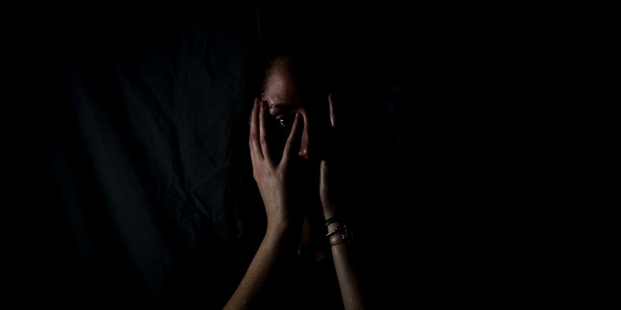 woman holding her face in dark room - Photo by Melanie Wasser on Unsplash
