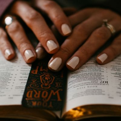 Closeup of hands touching an open Bible - Photo by Kelly Sikkema on Unsplash